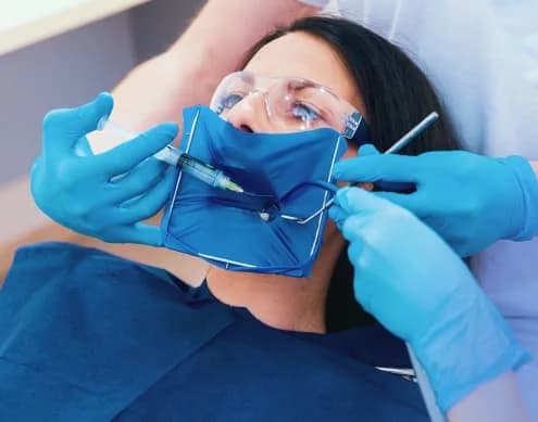 A dentist administering local anaesthesia to a patient before treatment