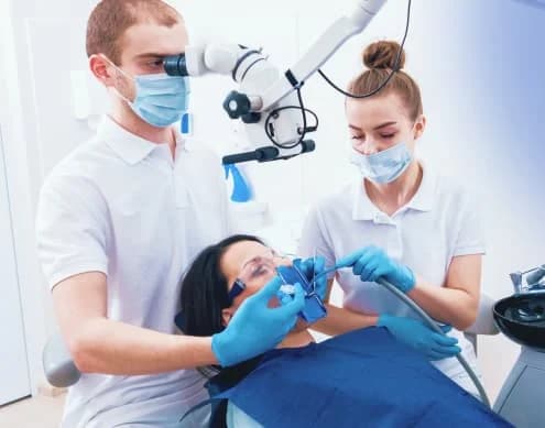 A Kayan dentist and assistant using a dental operating microscope during treatment